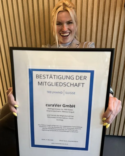 Melissa Vergult mit der gerahmten Bestätigung der Mitgliedschaft von curaVer bei TREUHAND|SUISSE